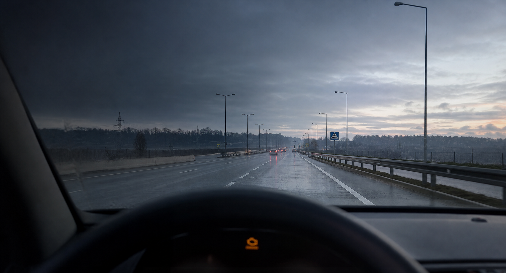 Widok z wnętrza samochodu na mokrą europejską drogę o świcie